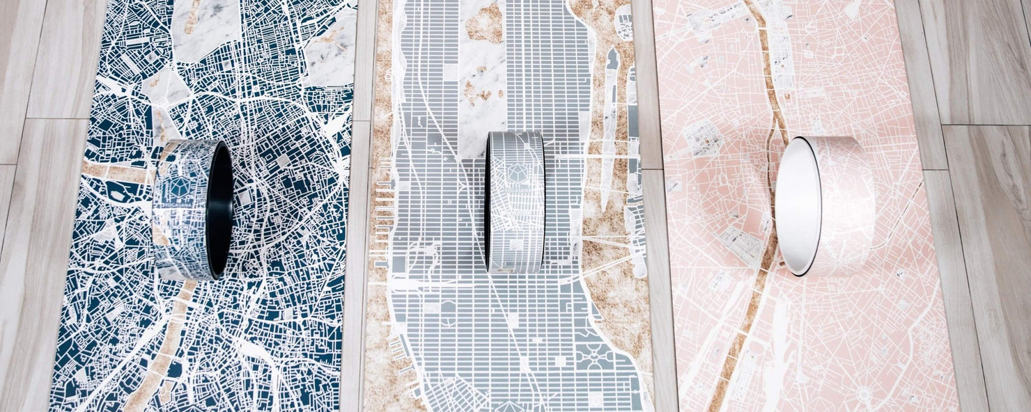 Three YOGASANA Urban Collection yoga mats and wheels inspired by city maps, capturing the textures and layered beauty of urban exploration