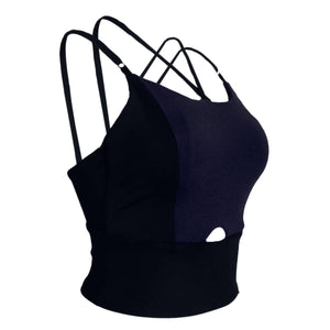 Product image of YOGASANA Cassie Cross-Back Performance Sports Bra in Misty London black and blue, showing the angled front view with contrast colour panel and cut-out detail.