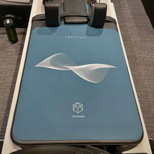 IMPETUS 2mm Pilates Reformer Mat - Navy Blue Edition placed on white reformer machine in studio