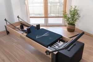 IMPETUS 2mm Pilates Reformer Mat - Navy Blue Edition on wooden reformer machine by YOGASANA