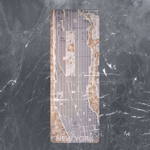 Flat lay of YOGASANA Urban Portrait 4mm Natural Rubber Yoga Mat – Midnight New York edition, showing artistic city map print in neutral marble tones.