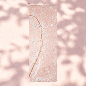 Flat lay of YOGASANA Urban Portrait 4mm Natural Rubber Yoga Mat – Daylight Paris edition, featuring artistic Paris city map in warm blush tones with golden river detail.