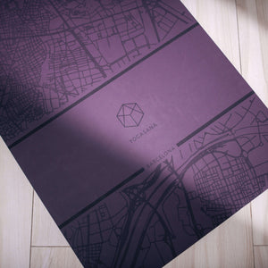 Close-up of YOGASANA Glamorous Barcelona yoga mat showing engraved map lines and brand logo.