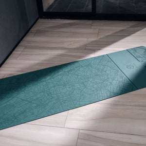 Diagonal flat lay of YOGASANA Urban Sketch Renaissance Milan yoga mat surface with light and shadow.