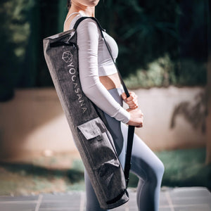 Model carrying Yogasana grey yoga mat bag outdoors