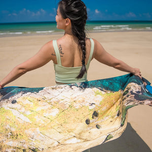 Back view of model holding Yogasana Island Garden double-sided yoga towel, inspired by Australian coastal textures.