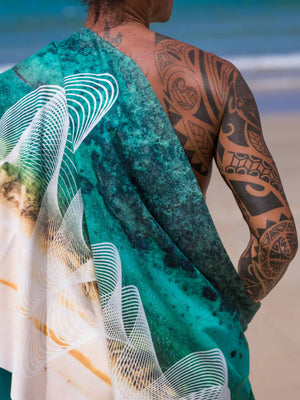 Close-up of man wearing Yogasana Gradient Balance yoga mat as a wrap, showing ocean-inspired green and white design with geometric pattern.