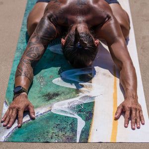 Yogasana Landscape Collection Gradient Balance yoga towel – man practicing yoga pose on sandy beach, featuring ocean gradient design.