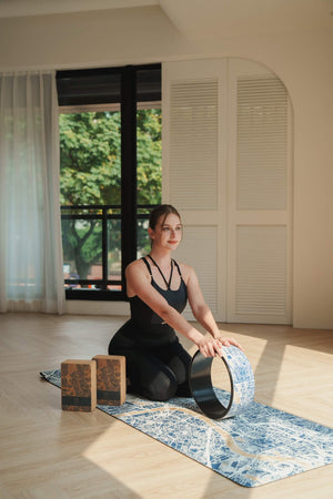 Yogasana Urban Portrait Misty London yoga mat and wheel, used in seated yoga practice with natural sunlight and calm tones.