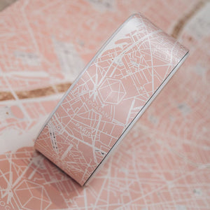 Close-up of Yogasana Urban Portrait Yoga Wheel with white geometric Paris map design on blush pink background.