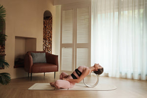 Heart-opening yoga pose using Yogasana Lumiere Sundial Wheel – White Golden edition in calm home studio.