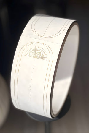 Close-up of Yogasana Lumiere Sundial Yoga Wheel – White with golden line pattern, highlighting fine suede texture.