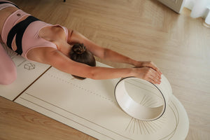 Overhead view of yoga stretch using Yogasana Lumiere Sundial Mat & Wheel – White Golden edition.